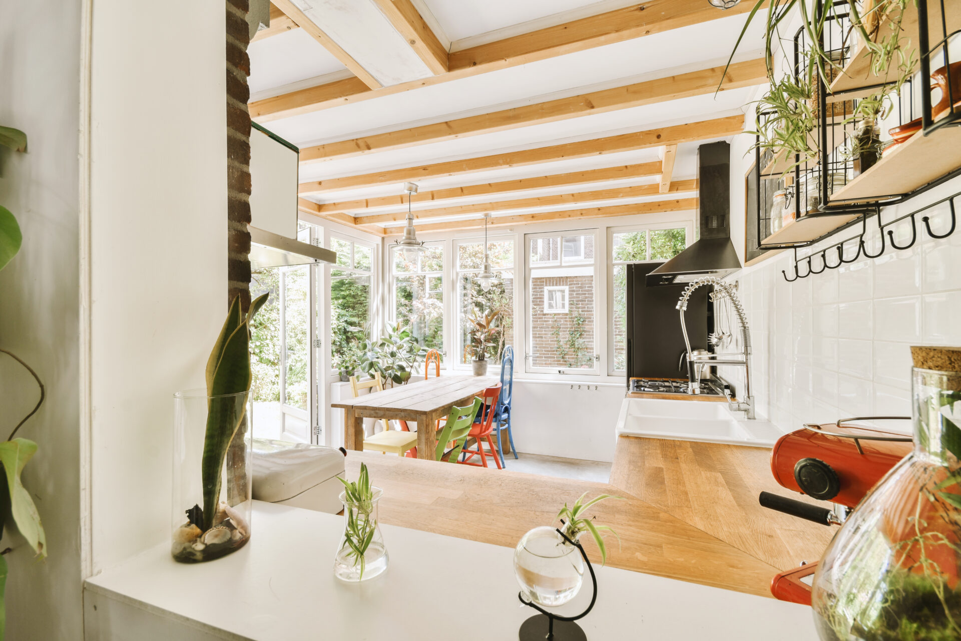 Home interior design of modern loft apartment with open kitchen in minimalist style and spacious dining zone with table and chairs